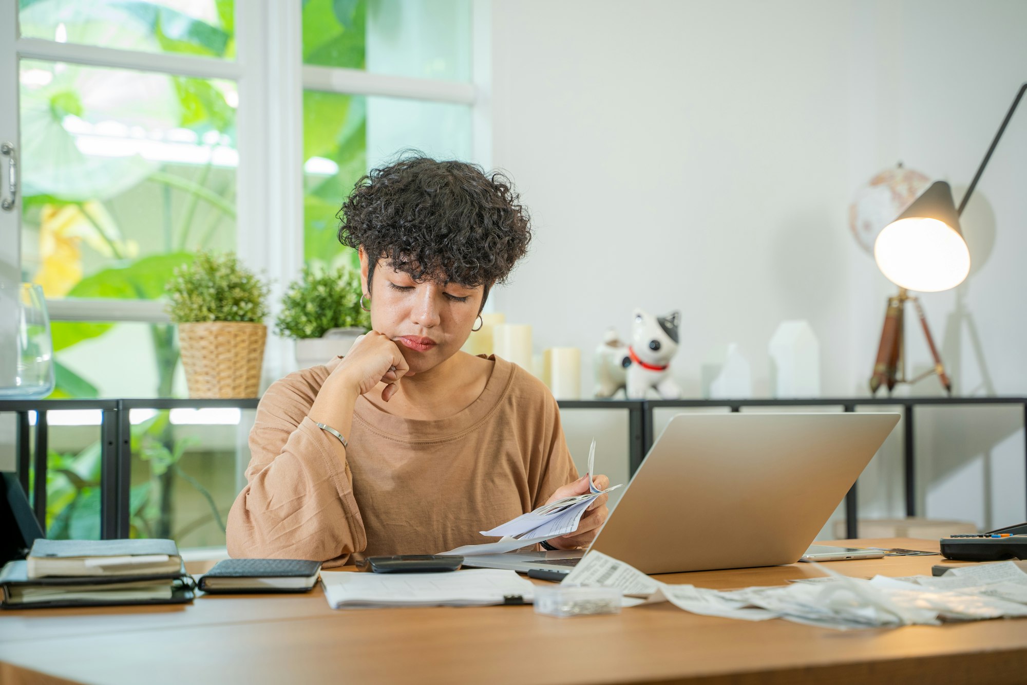 Woman stressed and confused by calculate expense from invoice or bill.
